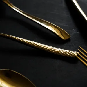 Close-up of gold 304 stainless steel cutlery with hammered texture and mirror finish