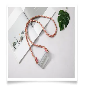 Close-up detail of a braided pink and beige crossbody phone strap with card holder