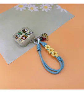 Macro view of blue and yellow braided wrist lanyard with cute cartoon storage case