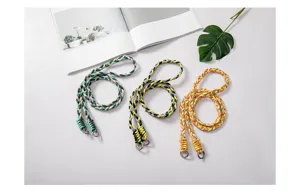 Detail of three multi-color braided phone straps with silver rings on a minimalist white background