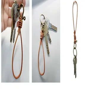 Detailed view of a hand-woven brown cowhide leather keychain with brass hardware.