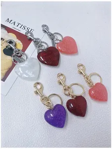 Detail view of colorful glitter heart keychains with gold and silver metal clasps
