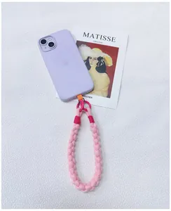 Macro view showing the soft texture of a pink handmade braided phone wrist strap with pink rings