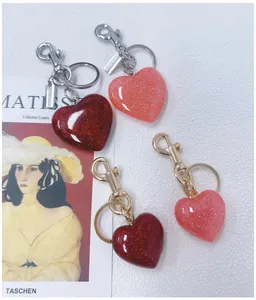 Detail of glitter heart keychains in red and pink with gold and silver clasps