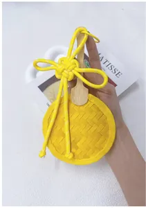 Detailed macro view of a handmade yellow woven bamboo fan ornament with a Chinese knot.