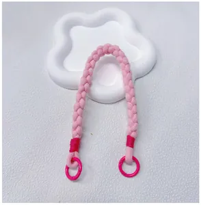 Close-up of pink braided phone wrist strap with pink metal rings and cotton cord detail