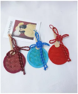 Close-up detail of three handmade woven bamboo fan charms with colorful Chinese knots.