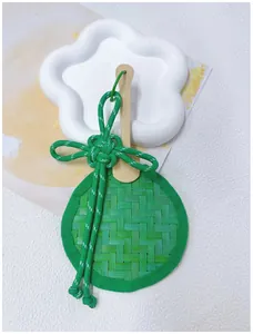 Detailed view of handcrafted green woven bamboo fan ornament with decorative knot