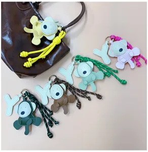 Close-up of handmade cartoon monkey bag charms featuring colorful braided rope and leather