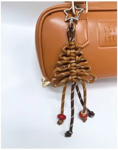 Nahaufnahme eines handgewebten Weihnachtsbaumanhängers mit Sternclip an einer Tasche