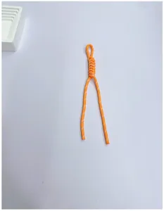 Detailed view of a bright orange handmade woven lanyard featuring a sturdy paracord knot.