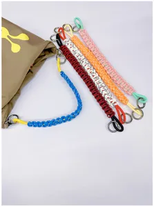Vibrant hand-woven paracord straps in various colors used as decorative bag handles