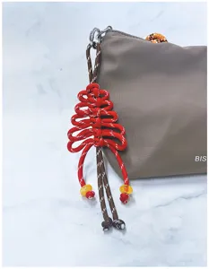 Primo piano di un ciondolo ad albero di Natale intrecciato a mano su una borsa marrone