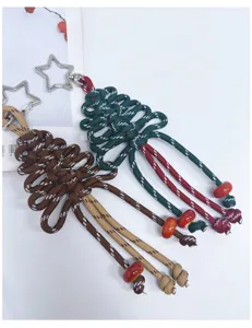 Detailansicht handgewebter Weihnachtsbaum-Taschenanhänger mit sternförmigen Schlüsselringen