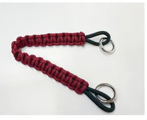 Detail view of handmade burgundy and black braided paracord lanyard with silver rings.