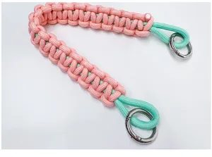 Handmade braided paracord hand strap in pink and mint green with durable silver metal rings