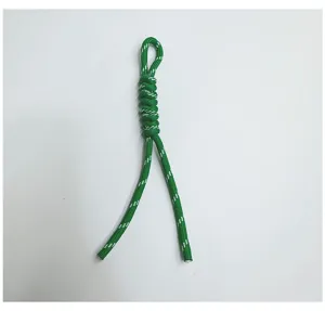 Detail of a green and white handmade braided snake knot lanyard for keys or bags.