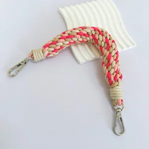 Primer plano de cordón grueso trenzado a mano en rosa y beige con cierres metálicos plateados