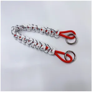 Detailed close-up of a handmade paracord wrist strap with red core and silver ring clasps
