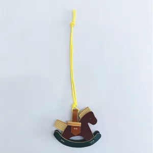 Detailed view of a handcrafted leather rocking horse bag charm with yellow cord