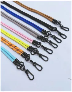 Detail view showing multiple colors of braided phone lanyards with black metal hooks.