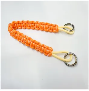 Close-up of a durable hand-woven orange paracord wrist lanyard with dual metal rings