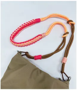 Detailed view of handmade woven crossbody strap with vibrant pink and orange knots