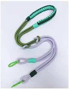 Detailed view of hand-woven crossbody strap with green carabiners and purple cords.