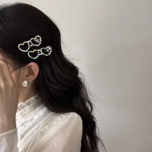 Detailed macro view of two colorful rhinestone heart glasses hair clips on wavy hair