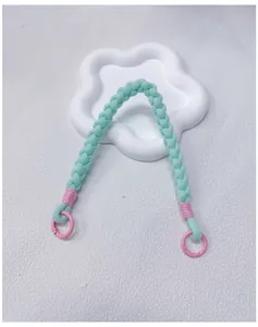 Close-up view of a handmade woven phone wrist strap in mint green and pink pastel colors.