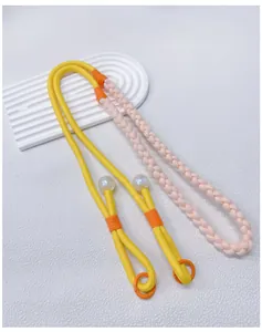 Detailed macro view of a hand-woven colorful crossbody phone lanyard and bag strap