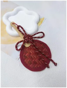 Detailed macro view of a handmade red bamboo woven fan charm with a decorative Chinese knot