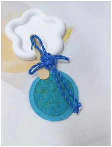 Close-up of a handmade blue bamboo woven fan ornament with a decorative cord knot