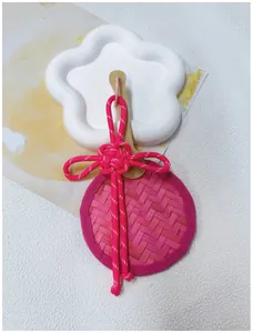 Detailed macro view of a pink handmade bamboo fan charm with traditional Chinese knot