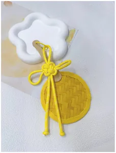 Detail of handmade woven bamboo fan pendant with elegant yellow Chinese knot cord