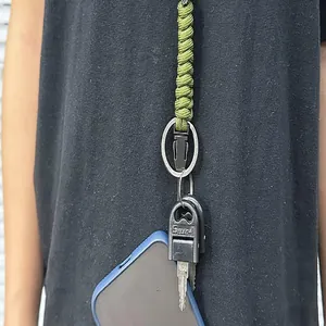 Close-up detail of a durable green braided paracord lanyard holding keys and a smartphone.