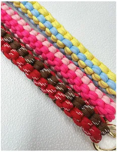 Detailed view of handmade braided colorful bag straps with gold metal ring buckles