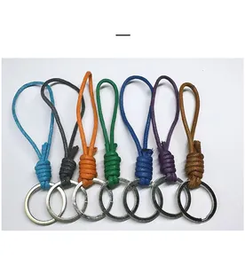 Detail view of seven colorful handmade woven wax rope keychains with metal rings