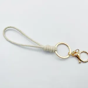 Minimalist beige braided wax cord keychain with a gold-tone lobster clasp and metal ring.