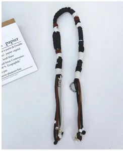 Handmade three-color woven cotton rope bag strap with metal rings and decorative beads.