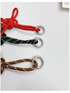 Detail of handmade woven Chinese knot keychains with silver rings in various colors.