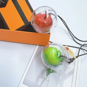 Detailed view of red and green simulation apple ornaments encased in clear plastic spheres