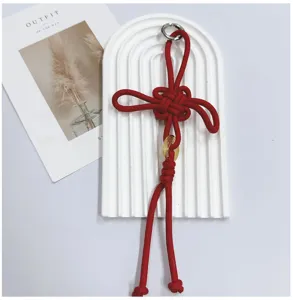 Detailed view of hand-woven red Chinese knot pendant with gold coin element