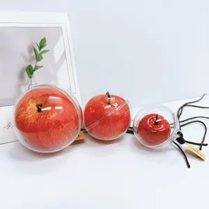 Close-up of three different sized realistic apple hanging ornaments in clear spheres.