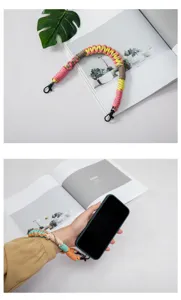 Colorful hand-woven phone wrist lanyard attached to a smartphone in a detailed view