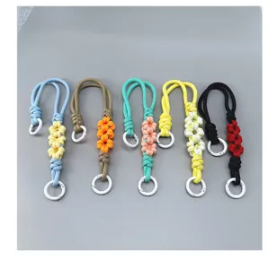 Detail view of five colorful handmade braided daisy wrist straps with white carabiner rings