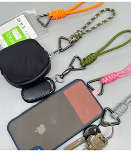 Detail shot of colorful woven paracord wrist lanyards attached to a phone, pouch, and keys.