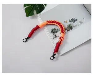 Close-up of handmade woven phone lanyard with orange and maroon cord and black clasp