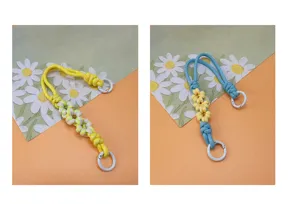 Close-up of hand-woven daisy patterned wrist lanyards in yellow and blue