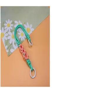 Detailed view of handmade braided daisy wrist strap phone lanyard with white clips